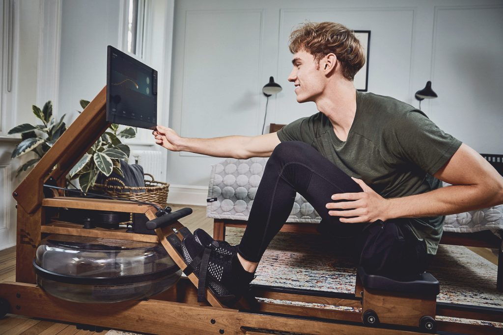 Close up of man on the rowing machine in his apartment